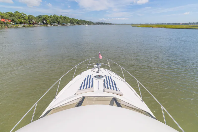 Slide: The Image of Bow view of 2006 Meridian 341 Sedan yacht cruising on a serene river. - 44