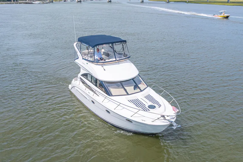 Slide: The Image of 2006 Meridian 341 Sedan cruising on a calm river with a bridge in the background. - 6