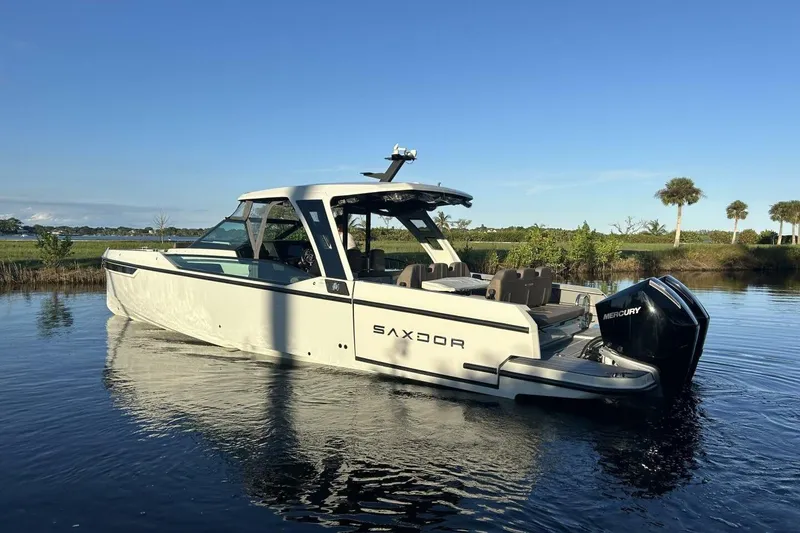 Slide: The Image of 2022 Saxdor 320 GTO boat on calm water, showcasing sleek design and powerful Mercury engine. - 3