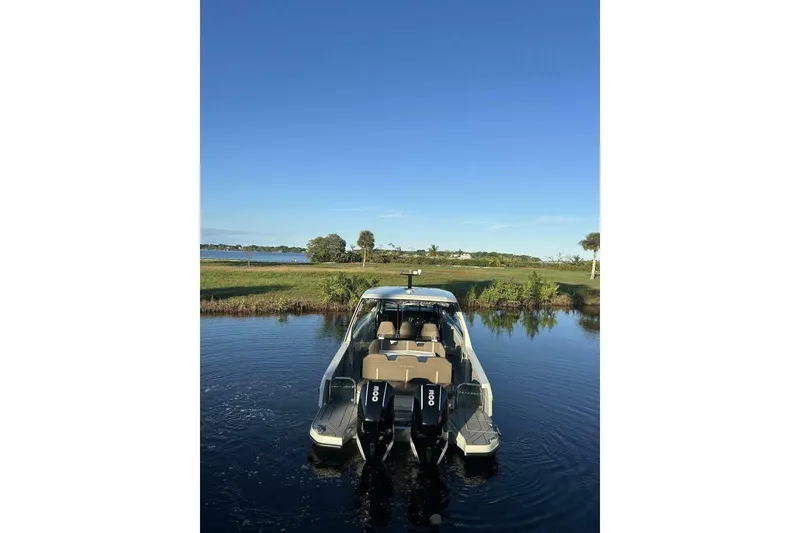 Slide: The Image of 2022 Saxdor 320 GTO boat on calm water with clear blue sky backdrop. - 4