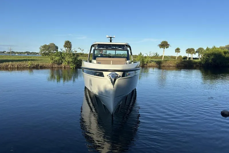 Slide: The Image of 2022 Saxdor 320 GTO boat on calm water with scenic background. - 5