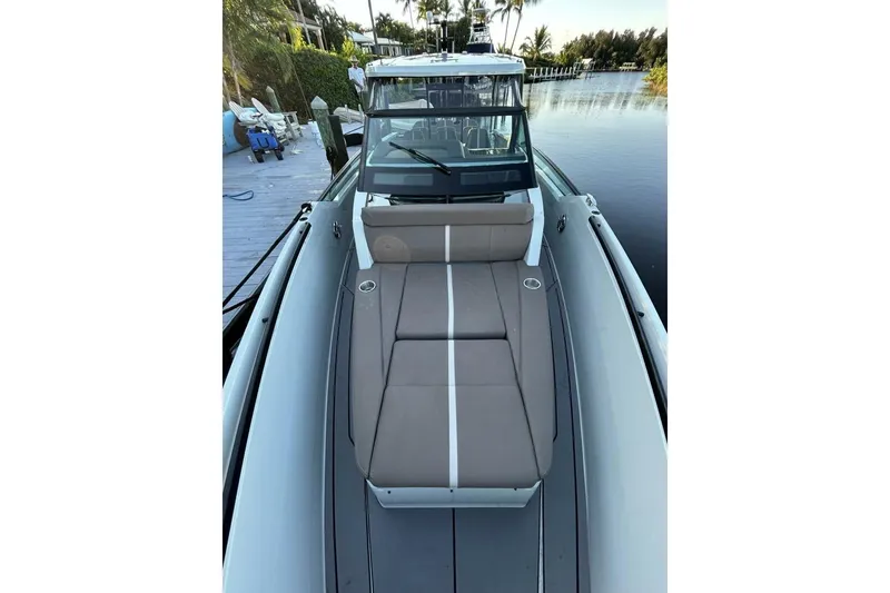 Slide: The Image of 2022 Saxdor 320 GTO boat with sleek design, docked by a serene waterfront. - 6