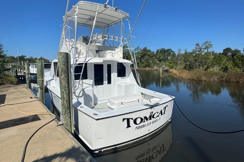 The Image of 1965 Hatteras 41 Convertible boat docked in a serene marina setting. - 1