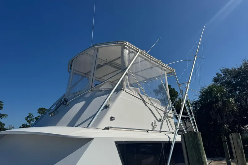 Slide: The Image of 1965 Hatteras 41 Convertible boat with clear skies and docked at marina. - 10