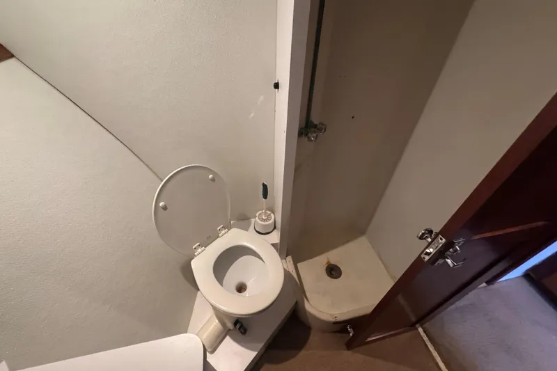 Slide: The Image of Bathroom interior of 1965 Hatteras 41 Convertible yacht, featuring toilet and shower. - 17