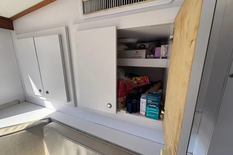 Slide: The Image of Interior storage cabinets on a 1965 Hatteras 41 Convertible boat, stocked with various items. - 22