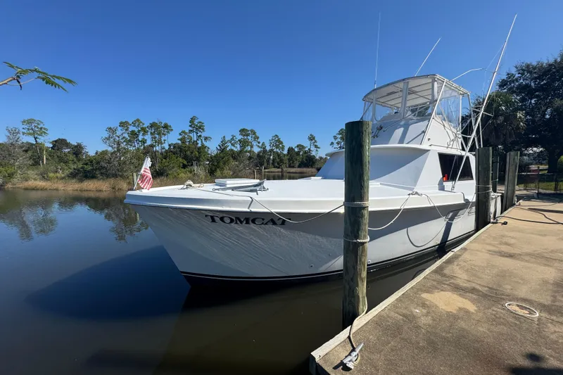 Slide: The Image of 1965 Hatteras 41 Convertible boat docked on a sunny day, named "Tomcat." - 6