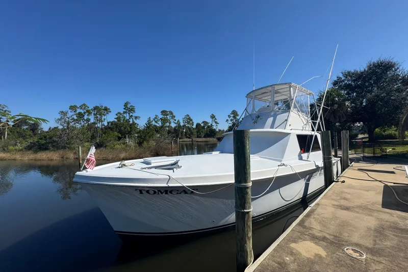 Slide: The Image of 1965 Hatteras 41 Convertible boat docked by a serene riverside. - 7