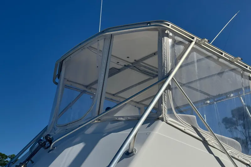 Slide: The Image of 1965 Hatteras 41 Convertible boat with clear enclosure against blue sky. - 8