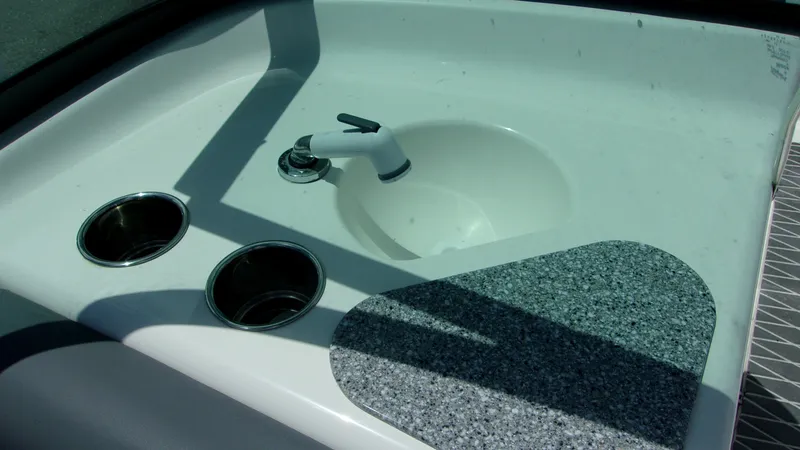 Slide: The Image of 2023 NauticStar 203 DC boat sink with faucet and cup holders. - 14