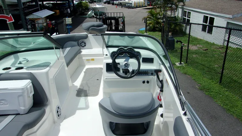 Slide: The Image of 2023 NauticStar 203 DC boat interior with steering wheel and seating area. - 4