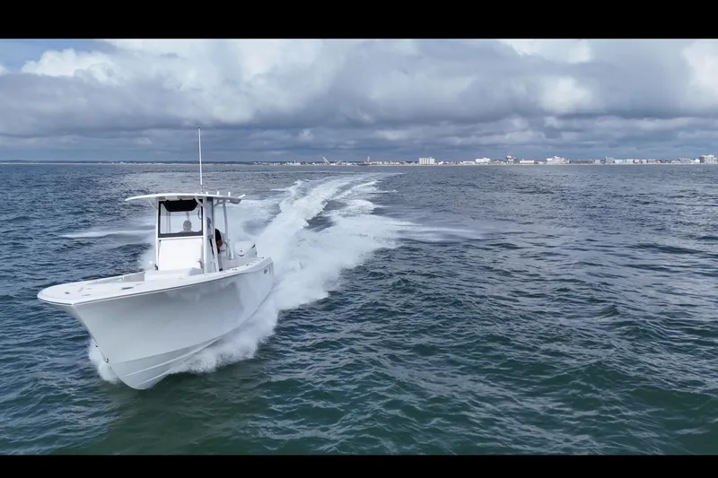 Slide: The Image of 2026 Pair Customs 28 Center Console boat on trailer, parked outside a garage. - 6