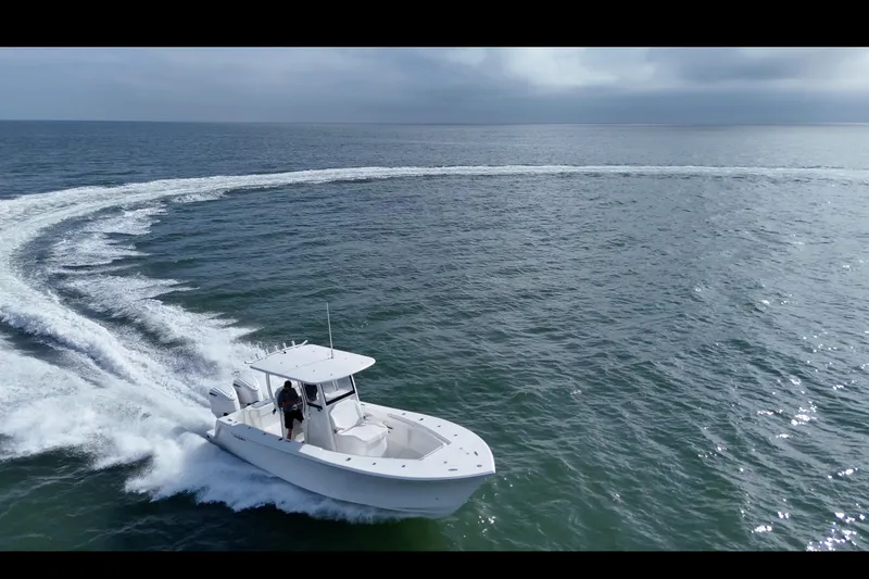 Slide: The Image of 2026 Pair Customs 28 Center Console boat on trailer, parked outdoors near a building. - 7