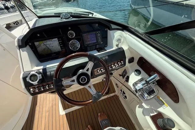 Slide: The Image of 2012 Sea Ray 300 Sundeck cockpit with steering wheel, navigation screens, and control panel. - 11