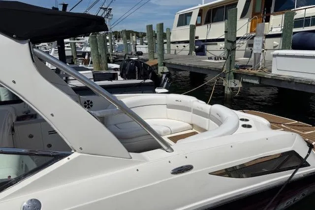 Slide: The Image of 2012 Sea Ray 300 Sundeck boat docked at marina, featuring sleek white design. - 3
