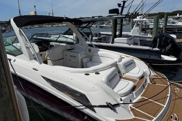 Slide: The Image of 2012 Sea Ray 300 Sundeck boat docked, featuring spacious seating and sleek design. - 4