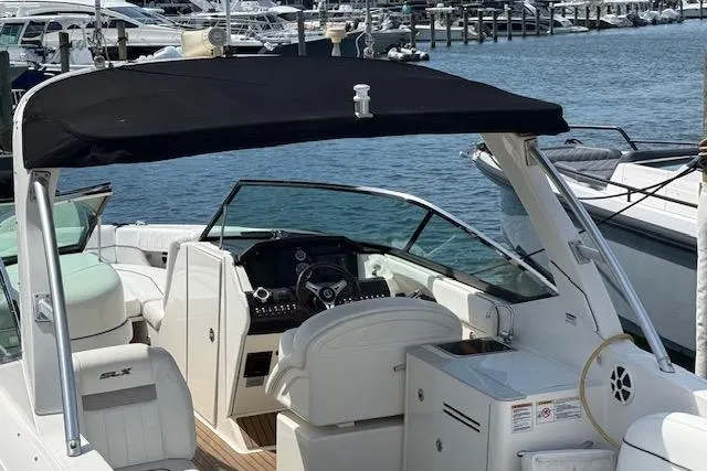 Slide: The Image of 2012 Sea Ray 300 Sundeck boat with black canopy docked in marina. - 5