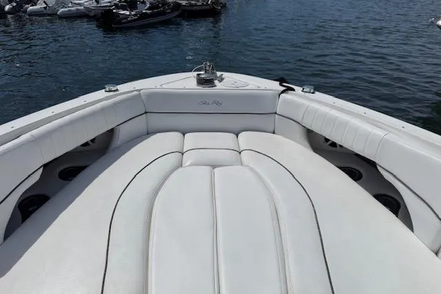 Slide: The Image of 2012 Sea Ray 300 Sundeck boat with white cushioned seating on calm water. - 6