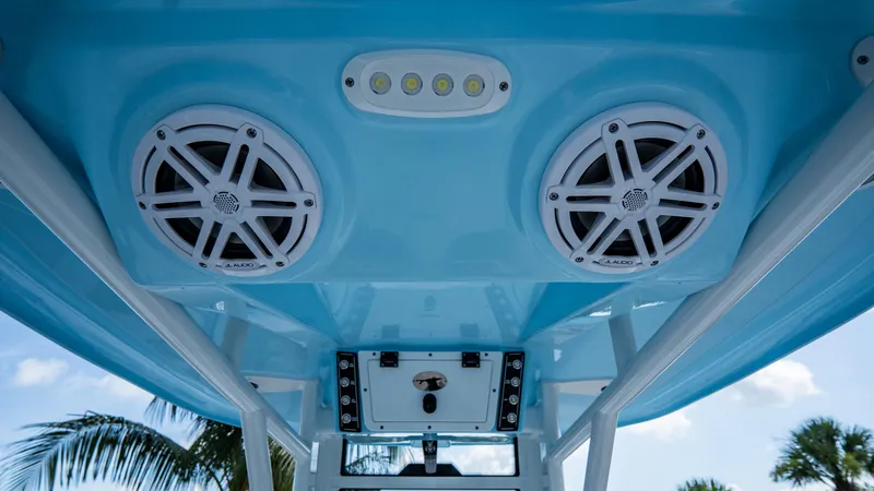 Slide: The Image of 2025 Tidewater 232 CC Adventure boat speakers and LED lights on blue canopy. - 12