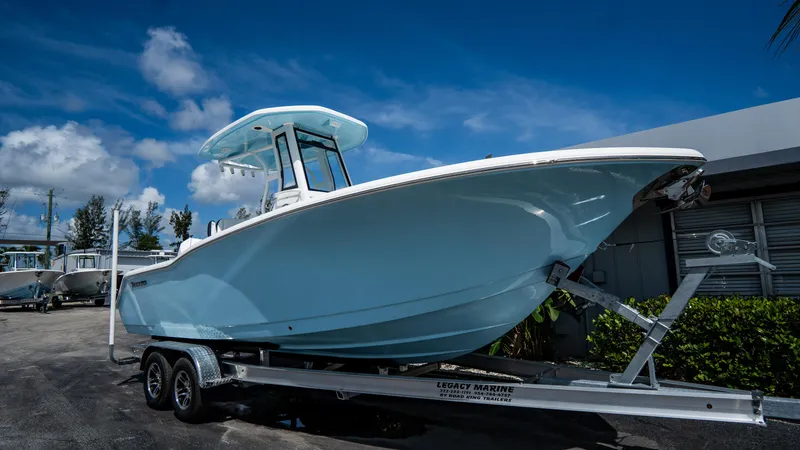 Slide: The Image of 2025 Tidewater 232 CC Adventure boat on a trailer under a blue sky. - 3