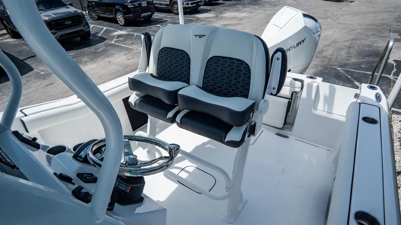 Slide: The Image of 2025 Tidewater 232 CC Adventure boat cockpit with dual seats and steering wheel. - 9