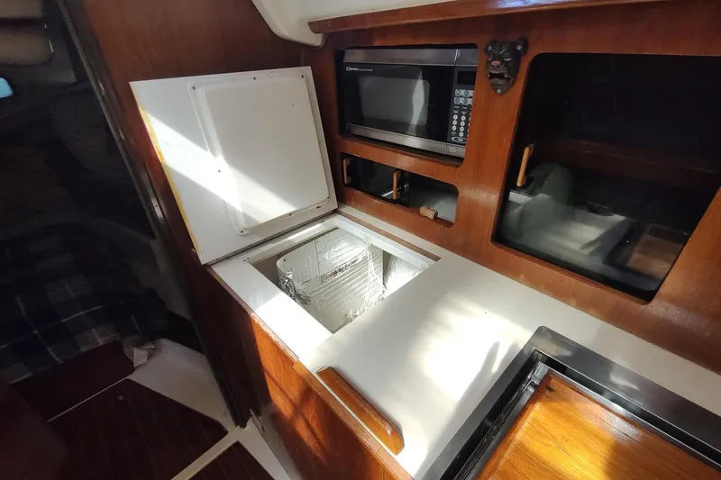 Slide: The Image of Interior of 1987 Hunter 37 Legend yacht with microwave and storage compartments. - 24