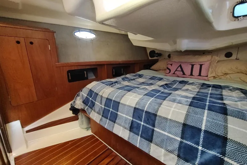 Slide: The Image of Cozy cabin interior of 1987 Hunter 37 Legend sailboat with plaid bedding and wooden accents. - 28