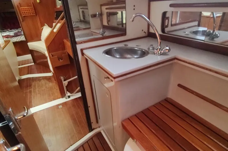 Slide: The Image of Interior of 1987 Hunter 37 Legend sailboat with wooden cabinetry and compact sink area. - 34