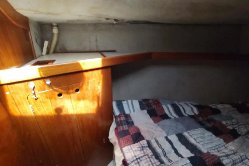 Slide: The Image of Cozy cabin interior of 1987 Hunter 37 Legend sailboat with wooden paneling and patterned bedding. - 50