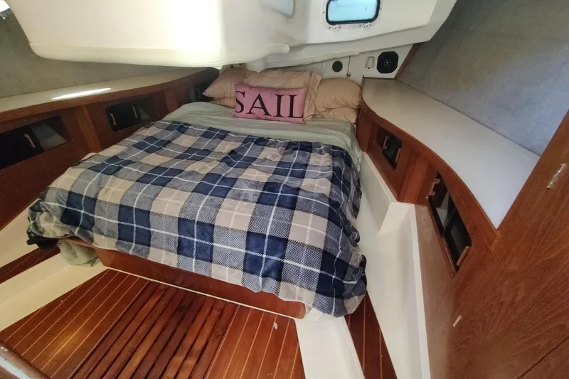 Slide: The Image of Cozy cabin interior of 1987 Hunter 37 Legend sailboat with plaid bedding and wood accents. - 30
