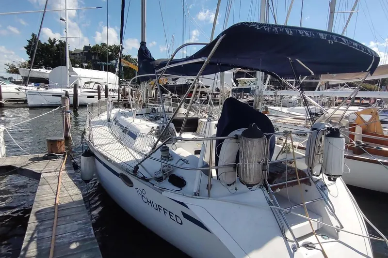 The Image of 1987 Hunter 37 Legend sailboat docked at marina, sunny day, blue canopy. - 3