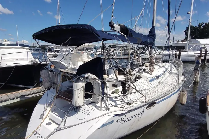Slide: The Image of 1987 Hunter 37 Legend sailboat docked at marina under clear blue sky. - 1