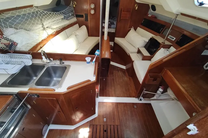Slide: The Image of Interior of 1987 Hunter 37 Legend sailboat with wooden cabinetry and cozy seating area. - 21