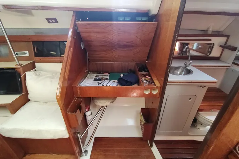 Slide: The Image of 1987 Hunter 37 Legend yacht interior with wooden cabinetry, seating, and compact kitchen area. - 36