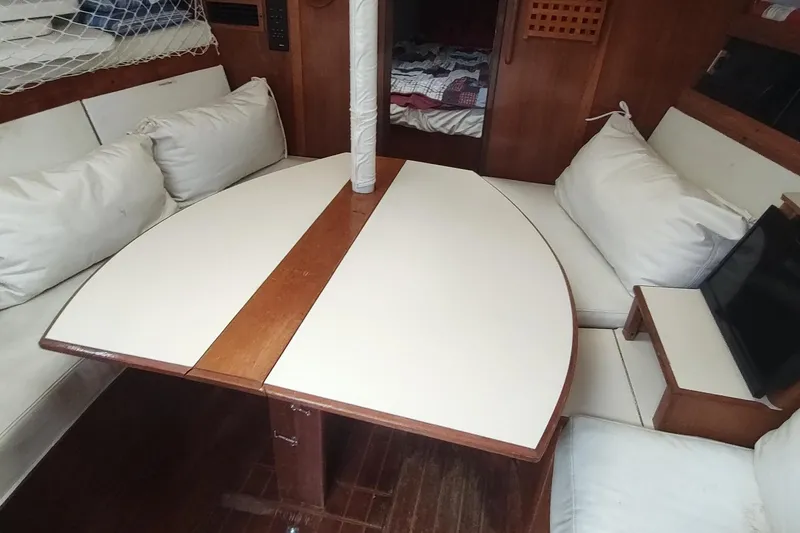 Slide: The Image of Interior of 1987 Hunter 37 Legend sailboat with cushioned seating and wooden table. - 42