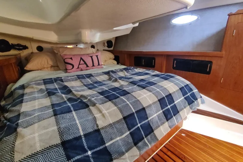Slide: The Image of Cozy cabin interior of 1987 Hunter 37 Legend sailboat with plaid bedding and "SAIL" pillow. - 29