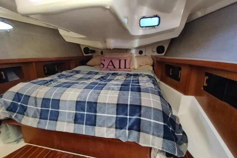Slide: The Image of Cozy cabin interior of 1987 Hunter 37 Legend sailboat with plaid bedding and wooden accents. - 26
