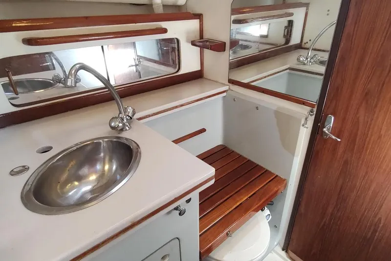 Slide: The Image of 1987 Hunter 37 Legend yacht bathroom with sink, wooden seat, and mirror. - 35