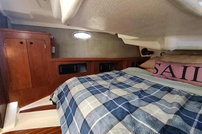 Slide: The Image of Cozy cabin interior of 1987 Hunter 37 Legend sailboat with plaid bedding and wooden cabinetry. - 31