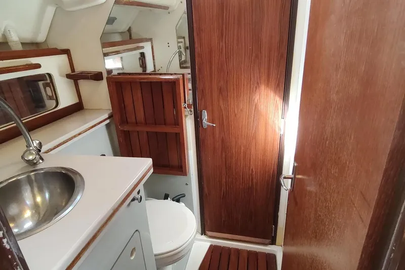 Slide: The Image of 1987 Hunter 37 Legend yacht bathroom with sink, toilet, and wooden cabinetry. - 33