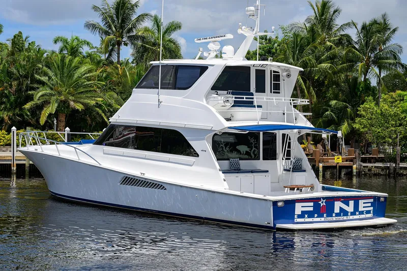 Slide: The Image of 2001 Viking 65 Enclosed Bridge yacht docked near tropical palm trees. - 11