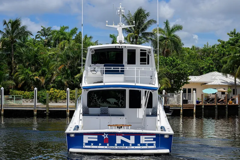 Slide: The Image of 2001 Viking 65 Enclosed Bridge yacht docked near tropical waterfront homes. - 12