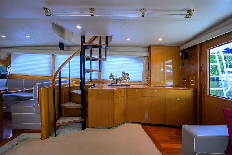 Slide: The Image of Interior of 2001 Viking 65 Enclosed Bridge yacht with spiral staircase and elegant wood finish. - 19