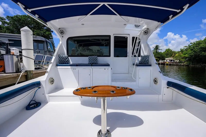 Slide: The Image of 2001 Viking 65 Enclosed Bridge yacht deck with seating and table, docked by water. - 22