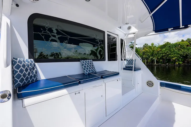 Slide: The Image of 2001 Viking 65 Enclosed Bridge yacht with blue seating and tropical backdrop. - 24