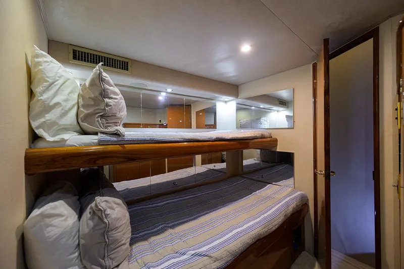 Slide: The Image of 2001 Viking 65 Enclosed Bridge cabin with bunk beds and wooden accents. - 28