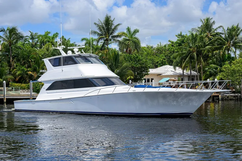 Slide: The Image of 2001 Viking 65 Enclosed Bridge yacht cruising near tropical waterfront home. - 3