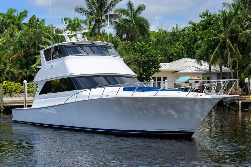 Slide: The Image of 2001 Viking 65 Enclosed Bridge yacht docked near tropical waterfront home. - 4