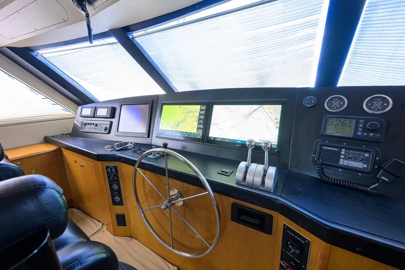 Slide: The Image of 2001 Viking 65 Enclosed Bridge helm with navigation screens and controls. - 44