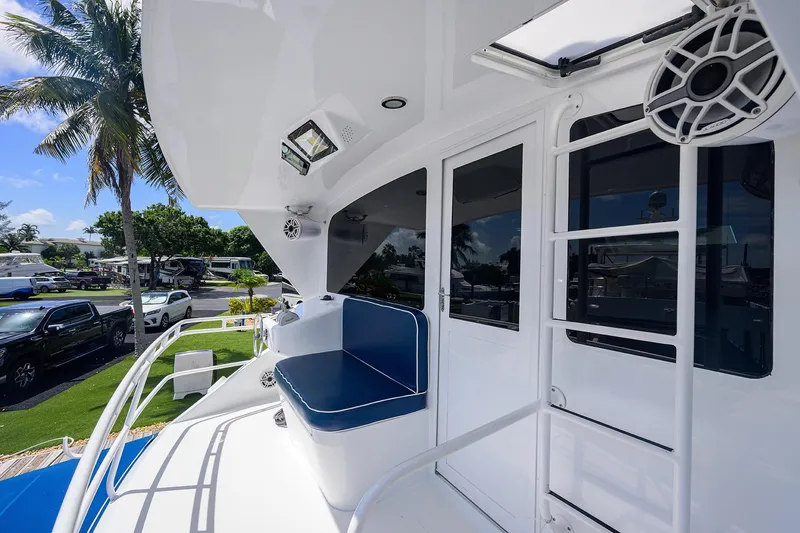 Slide: The Image of 2001 Viking 65 Enclosed Bridge yacht deck with seating, ladder, and outdoor speakers. - 48